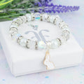 The white rabbit beaded bracelet sitting on top of the gift box it comes in. The gift box has our logo on it in silver foil on the lid. A personalised gift message can be printed for the underside of the lid.