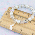 The white rabbit beaded bracelet against a ruler to show the dimensions.